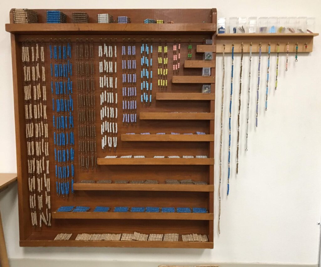 A Montessori bead chain, used for learning counting and math, hangs on the wall